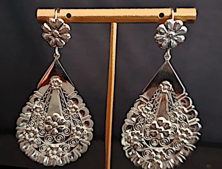 Aretes arracada Lágrima Jardín exhibidos en un soporte en el taller